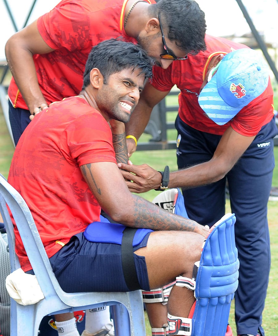 Mumbai's Surya Kumar Yadav receives treatment after he suffered a blow during nets on the eve of their semifinal against Hyderabad in Bengaluru on Tuesday. DH Photo/ Srikanta Sharma R
