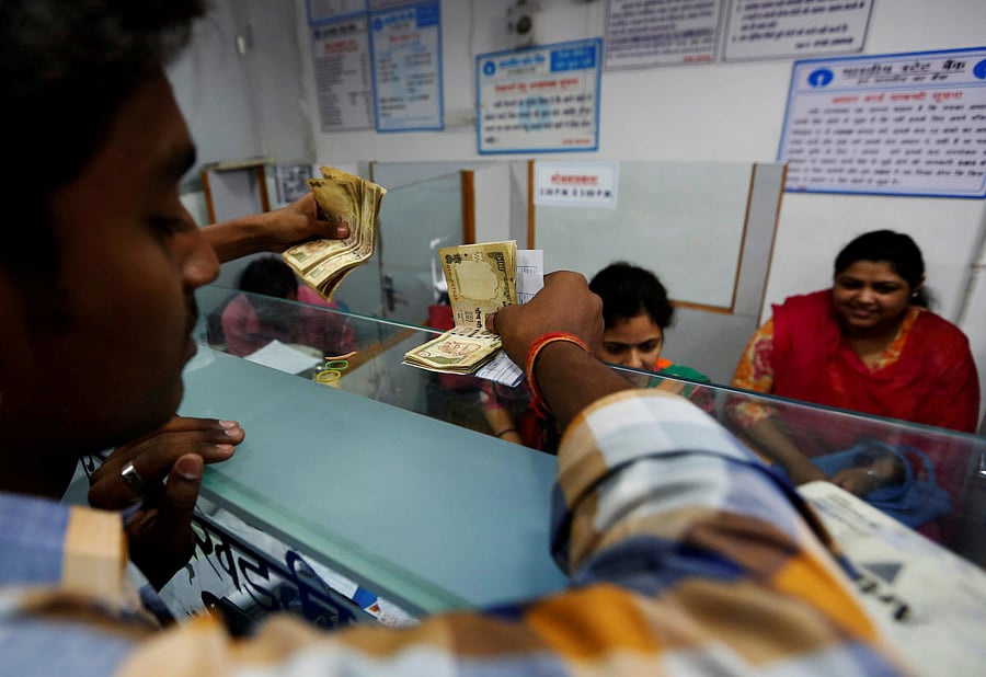 Flash Back: People hold their old high denomination bank notes as they stand in a queue to deposit them inside a bank in the northern city of Kanpur on November 10, 2016. REUTERS