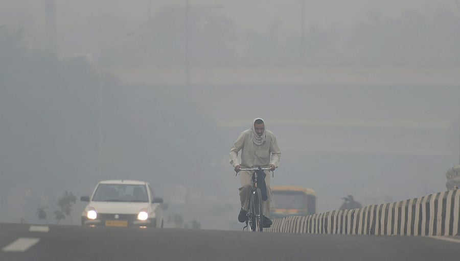 A cyclist rides through heavy haze, in New Delhi. PTI photo