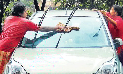 Two women clean a car in Technopark in Thiruvananthapuram.