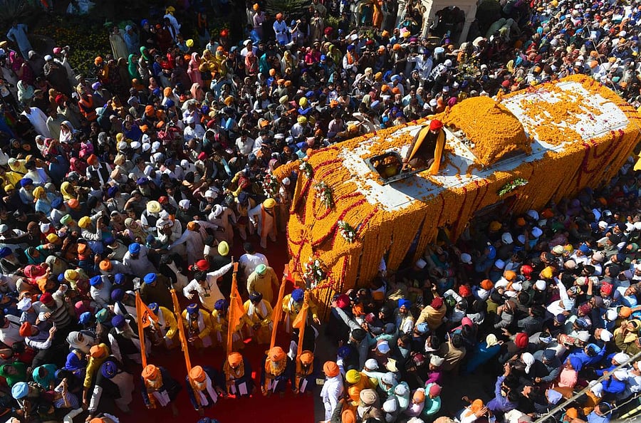 Sikh Pilgrims gather around the Palki Sahib on the occasion of the 549th birth anniversary of Guru Nanak Dev in Nankana Sahib, a district in the Punjab province of Lahore on Friday. AFP