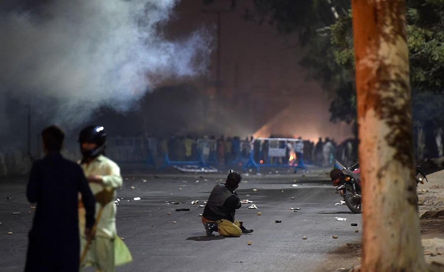 A Pakistani policeman fires teargas towards protesters during clashes after the arrest of hardline cleric Khadim Hussain Rizvi in Karachi on November 24, 2018. AFP