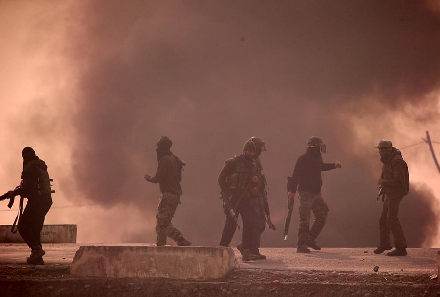 Security personnel in action as smoke billows during clashes with protesters following the killing of six suspected militants, in south Kashmir's Shopian district on Sunday. REUTERS