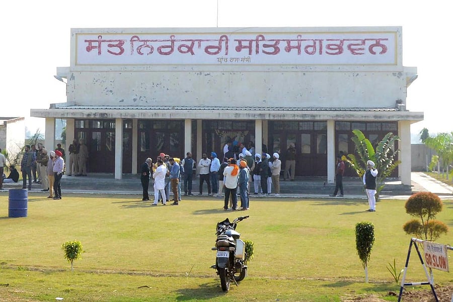 Members of the Nirankari spiritual group stand outside a building following a grenade attack at the Nirankari Satsang Bhawan centre in Rajasansi village, on the outskirts of Amritsar. AFP File Photo