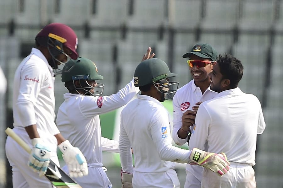 Mehidy Hasan (right) celebrates with team-mates after the dismissal of Devendra Bishoo in Dhaka on Sunday. AFP