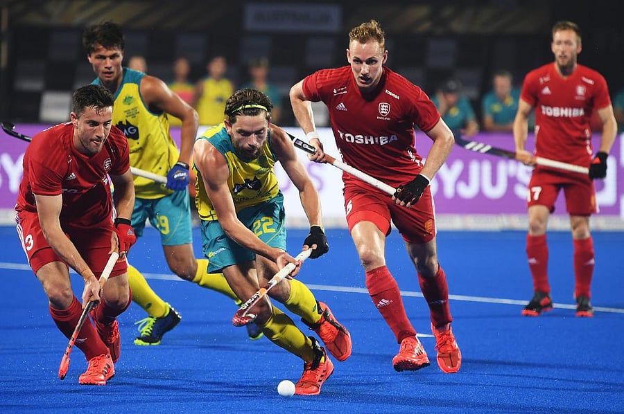 Australia's Flynn Ogilvie (centre) attempts to dribble past England players during their pool game on Tuesday. AFP