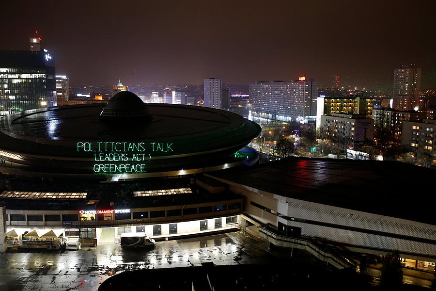Greenpeace environmental activists project words 'Politicians talk, leaders act. Greenpeace' on the roof of the venue of the COP24 UN Climate Change Conference 2018 in Katowice, Poland December 9, 2018. Agencja Gazeta/Grzegorz Celejewski via REUTERS ATTEN