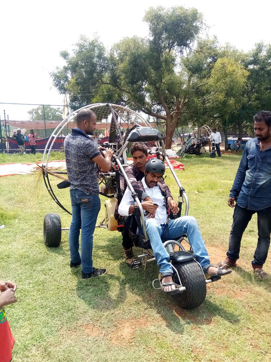An adventure buff gets ready for paragliding, organised by BASE, as part of Mysuru Dasara celebrations, at Maharaja's Cricket Stadium on Monday.