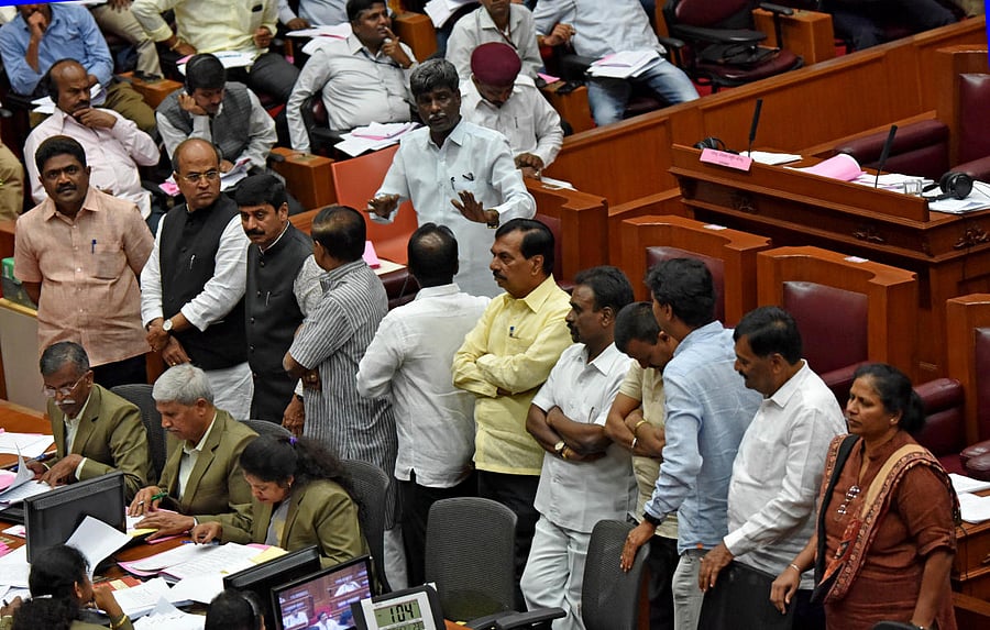 BJP members, led by their leader Kota Srinivas Poojary, stage a dharna in front of the chairman over alleged irregularities in Ganga Kalyana Scheme in the Legislative Council. DH photo / M S Manjunath
