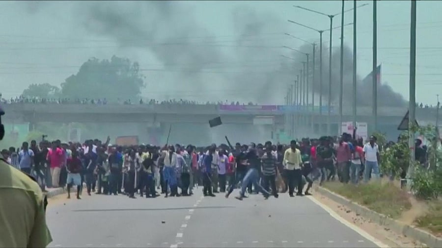 People pelt stones during a protest against the construction of a copper smelter by Vedanta Resources from the road, in Thoothukudi, Tamil Nadu, India in this still image from May 22, 2018 video footage. Video taken May 22, 2018. (ANI via REUTERS)