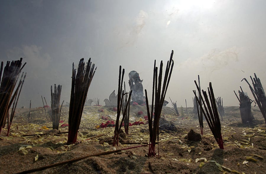Incense sticks burn as a girl prays during a prayer ceremony for the victims of the 2004 tsunami on the 14th anniversary of the disaster, at Marina beach in Chennai. (Reuters Photo)