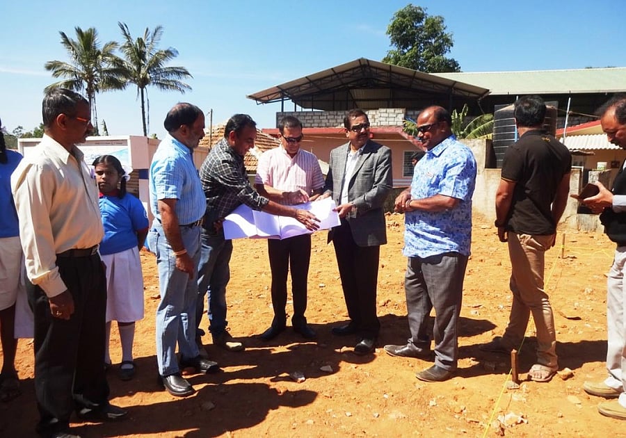 AKKA members inspect the land for the construction of the school building at Makkandooru in Madikeri taluk on Saturday.