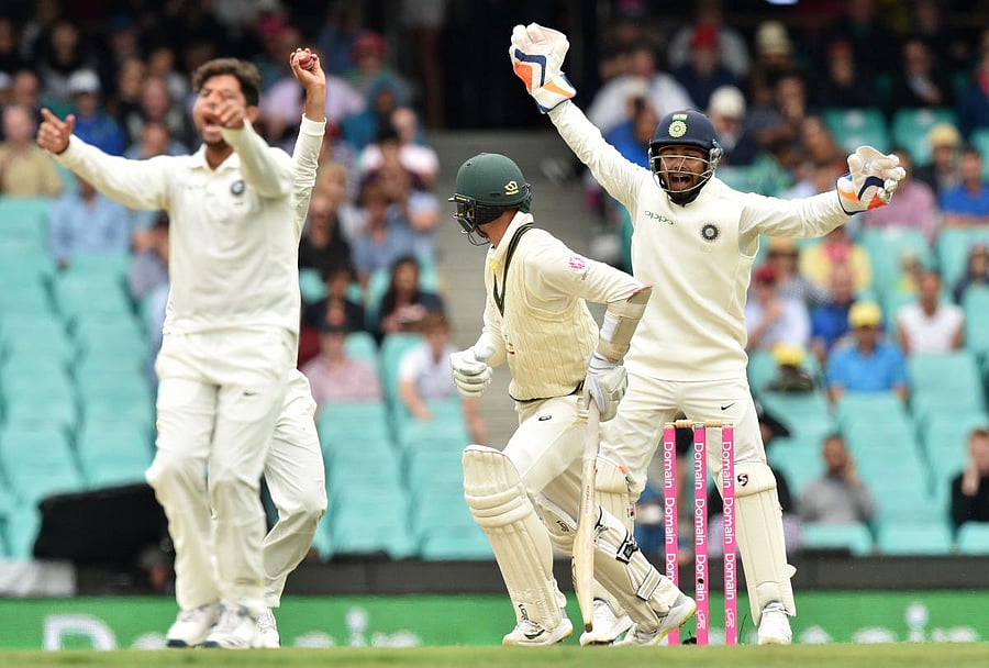 Australia's batsman Nathan Lyon is bowled LBW by India's Kuldeep Yadav (L), as India's wicketkeeper Rishabh Pant (R) shouts, on the fourth day of the fourth and final cricket Test at the Sydney Cricket Ground in Sydney on January 6, 2019. (AFP Photo)