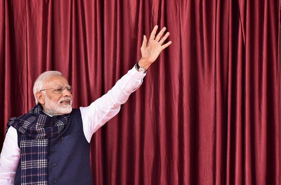 Prime Minister Narendra Modi waves to the crowd as he arrives in Medininagar on January 5 during a campaign sweep through Jharkhand state to inaugurate development projects. AFP