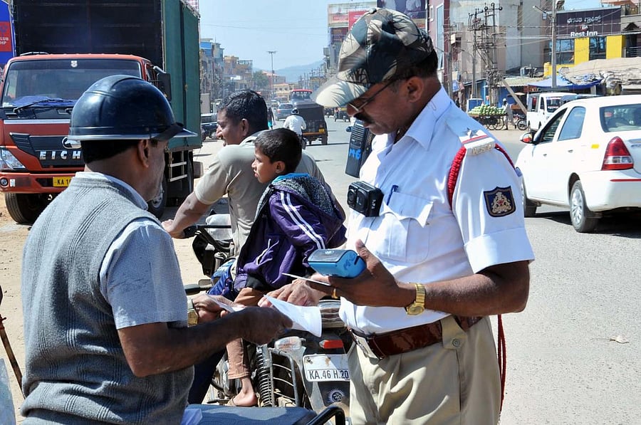 An ASI wears a body camera while inspecting a vehicle in Chikkamagaluru.