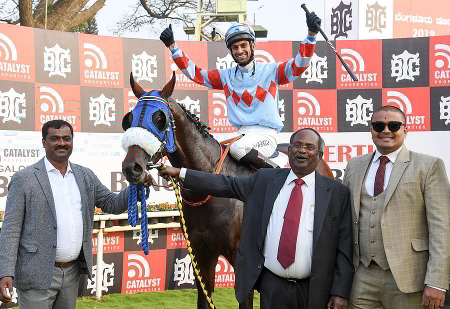 Owners A Muniraja (extreme left) and Nanda Kumar N (extreme right), jockey P Trevor and trainer G Nityanand lead in The Invader, the winner of the Catalyst Properties Bangalore Derby, at the BTC on Saturday. DH PHOTO/BH SHIVAKUMAR 