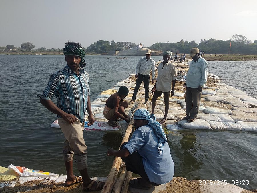 Workers lay the connecting bridge to the island at Triveni Sangama, in T Narsipur, Mysuru district, for the 11th Kumbha Mela.