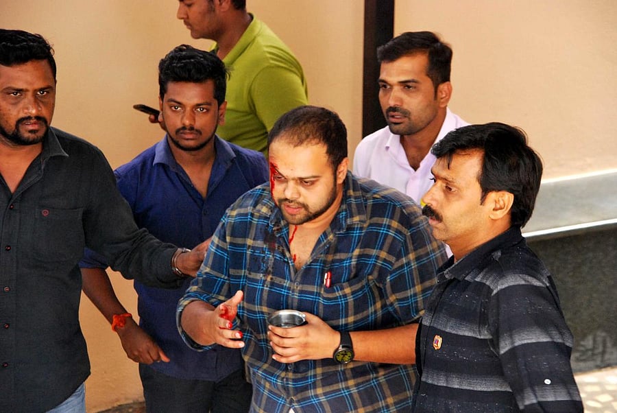 Injured BJP worker Rahul being escorted to hospital. DH photo