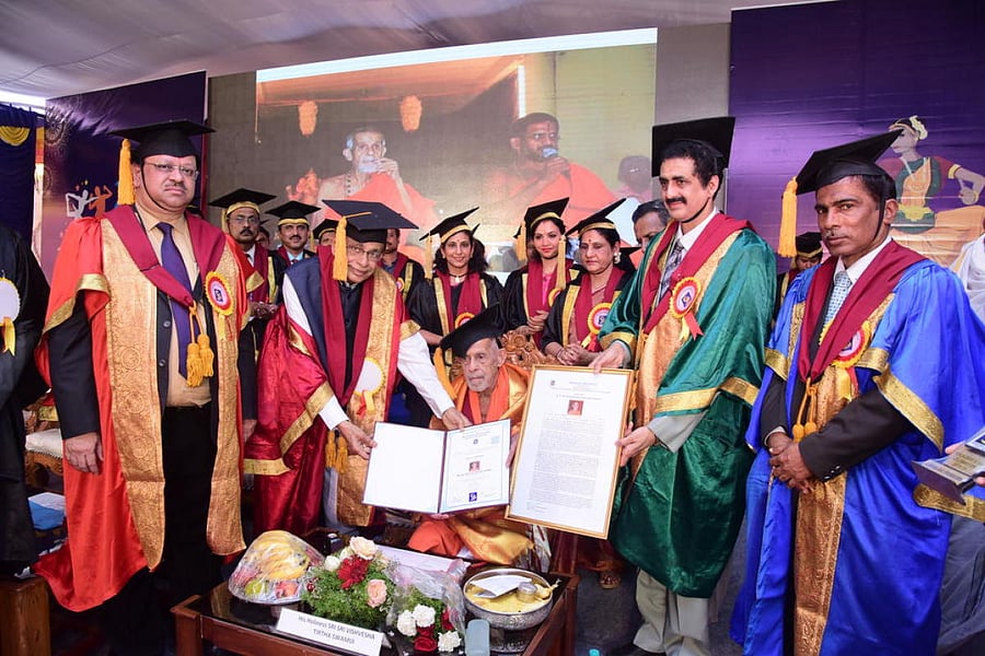Srinivas University Chancellor A Raghavendra Rao confers an honorary doctorate on Pejawar seer Vishwesha Theertha Swami, during the first convocation of the university on Friday.