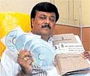 BBMP JD(S) leader Padmanabha Reddy displays CDs and files said to be containing details of the Rs 169-crore scam in the Palike, on Wednesday. DH Photo