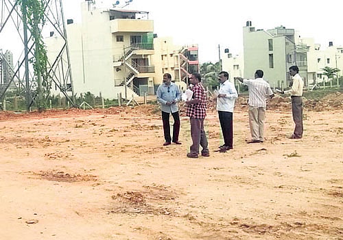 Bangalore South Tahsildar Dr Dayananda inspects the tank bed layout in Gubbalala village in Uttarahalli hobli. DH Photo