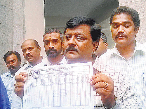 BJP's Kacharakanahalli ward corporator Padmanabha Reddy shows a fake A-Khata. DH PHoto