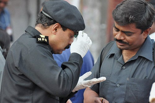 Members of the National Security Guard (NSG) inspect one of the blast site at Dilsukh Nagar district in Hyderabad on Friday. PTI