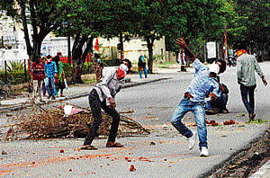 Student protesters supporting the demand for the creation of a new Telangana state throw stones at police in Hyderabad on Wednesday.  AP