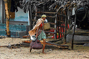 A woman carries her belongings to a shelter at Donkuru village in Srikakulam district on Saturday. Reuters