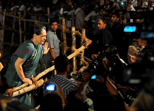 Congress President Sonia Gandhi meets the people by climbing barricades after a public meetingat Andole in Medak district of Telangana region on Sunday. PTI Photo