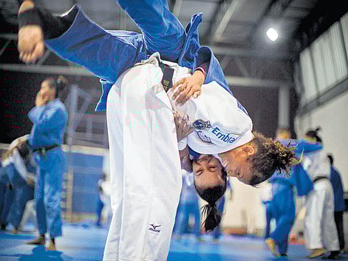 battler Rafaela Silva, in white, who grew up in the Cidade de Deus (City of God) slums of Rio de Janeiro, spars at a gym in the city where she began training in judo as a child. Silva, a world champion, is Brazil's gold medal hope at Rio. The New York Times