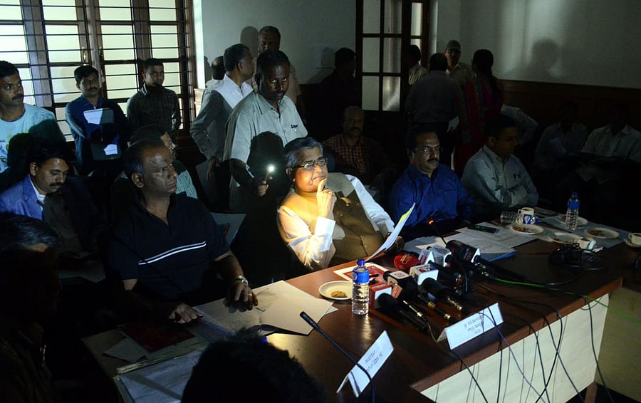 Legislative Assembly Speaker K B Koliwad uses cell phone flashlight to read out a press note after the power went off during the media briefing at Suvarna Vidhana Soudha in Belagavi on Sunday. DH photo