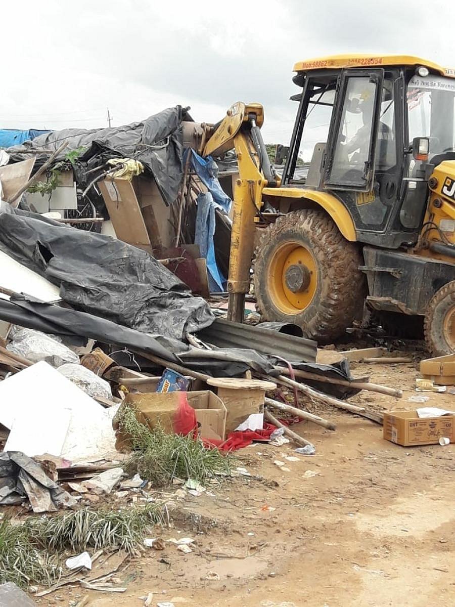 BBMP's earthmovers demolish a tin-roofed house on Saturday, in Bellandur, Bengaluru. (DH photo)