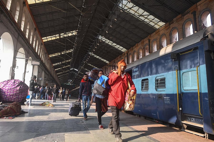 Indian commuters walk to catch their train at Sealdah railway station on January 8, 2019 (Photo by Dibyangshu SARKAR / AFP)