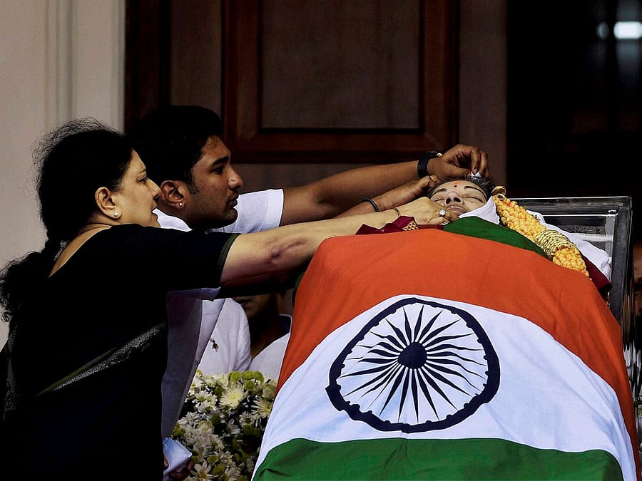 V Sasikala, the close aide of Tamil Nadu's former Chief Minister Jayaram Jayalalithaa adjusts a cloth around her body, kept for public viewing at Rajaji Hall in Chennai on Tuesday. PTI Photo