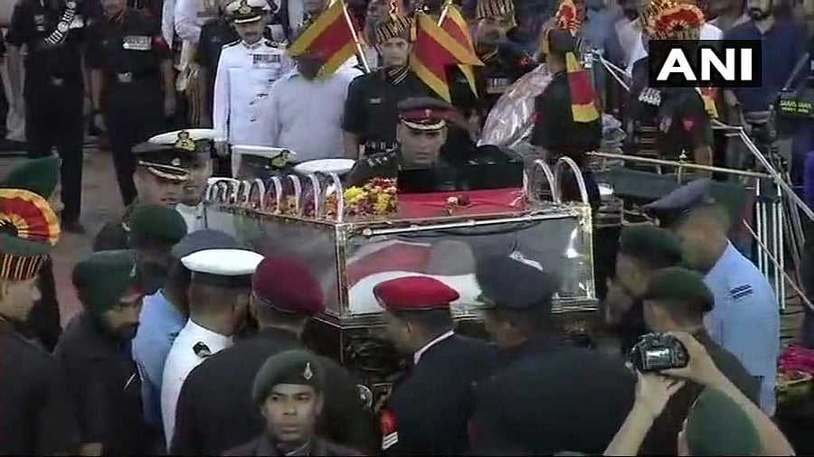 The military gun carriage (rpt military gun carriage) inched its way to the Marina beach about 1.7 km from Rajaji Hall with thousands of people lining up on the roads to catch a last glimpse of the departed leader. ANI photo