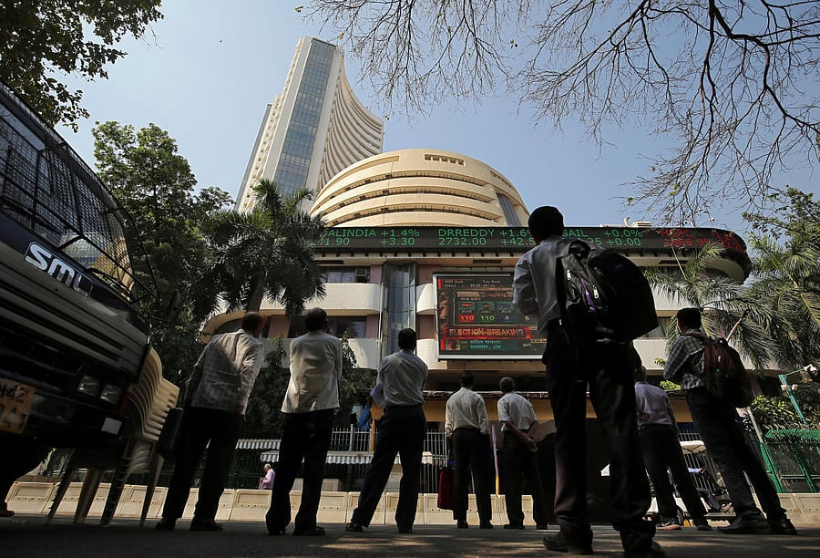 FILE PHOTO: People look at a screen displaying the Sensex results on the facade of the Bombay Stock Exchange (BSE) building in Mumbai. REUTERS
