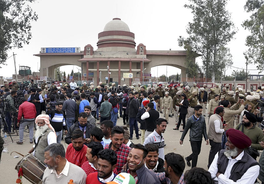 People jubilate with a Tricolour as they wait for the arrival of IAF pilot Wing Commander Abhinandan Varthaman at Attari-Wagha border near Amritsar. PTI photo