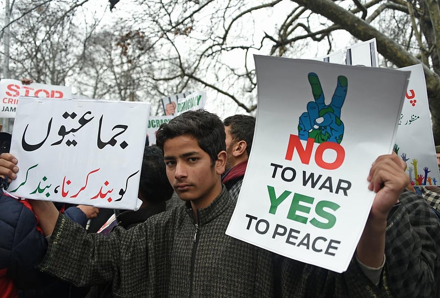 TOPSHOT - A supporter of the pro-Indian political party People's Democratic Party (PDP) holds placards during a protest in Srinagar on March 2, 2019, against the Jamaat-e-Islami ban. - Indian authorities banned the Kashmiri socio-religious organisation Ja