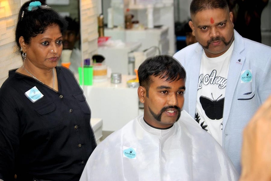 Nanesh Thakur (behind) gave over 650 people a look similar to that of Abhinandan free of cost.