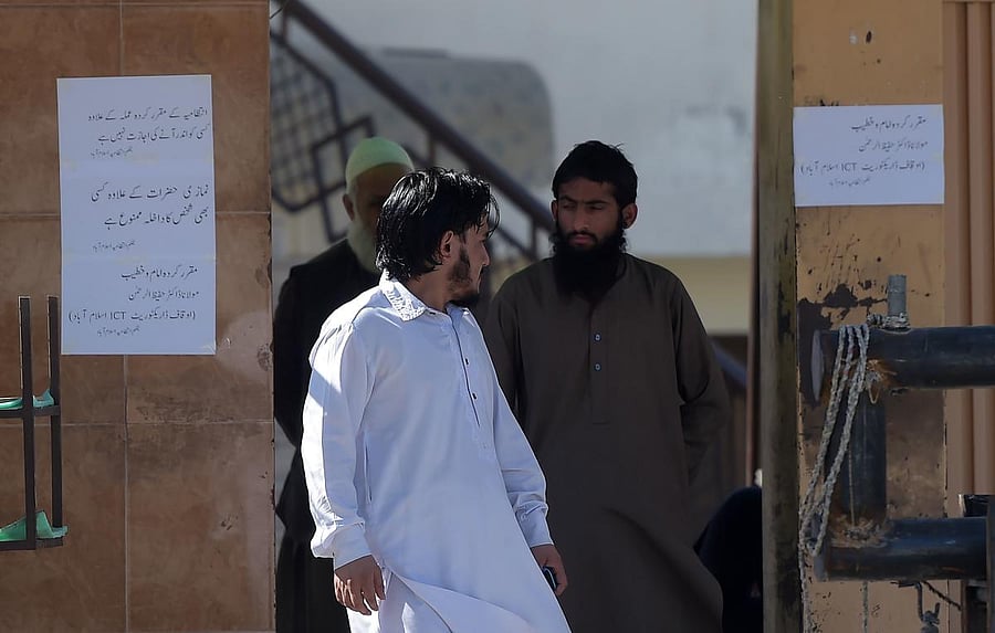 A worker of banned militant Jamaat-ud-Dawa (JuD) - an organisation believed by the United Nations (UN) to be a front for the banned Islamist militant group Lashkar-e-Taiba – stands at the main entrance of a mosque belonging to the (JuD) in Islamabad. (AFP Photo)