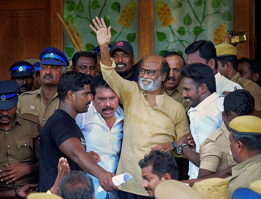 Actor-turned-politician Rajinikanth waves at supporters as he comes out of a government hospital after visiting those who got injured Tuticorin police firing, in Madurai on Wednesday. PTI