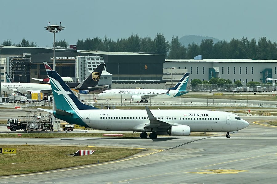 A SilkAir Boeing 737 MAX aircraft (background C) is parked on the tarmac of Changi International Airport in Singapore. AFP photo