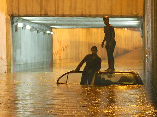 Occupants of a submerged car stranded at the waterlogged K R Circle underpass in Bangalore on Saturday. DH Photo/ Kishor Kumar Bolar