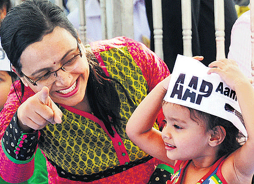 See, Arvind Uncle! An AAP supporter with her kid at a rally in Bangalore on Sunday. DH photo/kishor kumar bolar