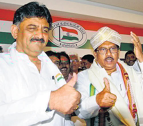 Minister D K Shivakumar and KPCC president G Parameshwara show thumbs up in celebration of the Congress's victory in the bypolls. DH photo