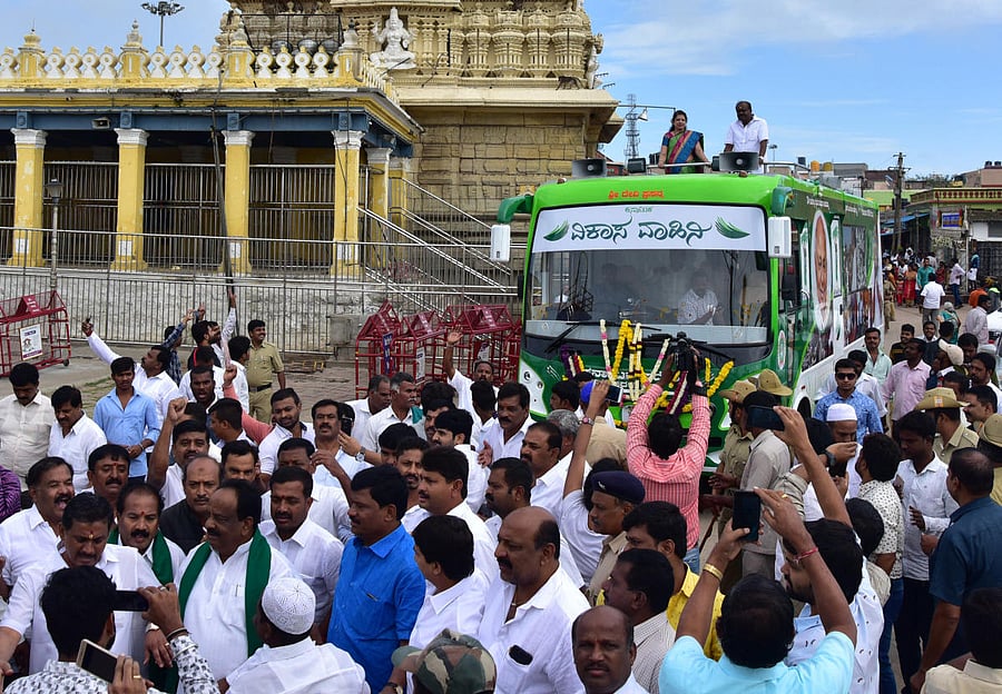 JDS state president H D Kumaraswamy with his wife Anitha Kumaraswamy seen on top of bus during inaugural ceremony of Vikasa Vahini bus, at Chamundi Temple premises, Chamundi Hills in Mysuru on Tuesday. dh PHOTO