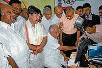 Chief Minister B S Yeddyurappa enrolling his name at the UIDAI stall, at Dasara exhibition grounds in Mysore on Friday. District In-Charge Minister S A Ramdas, MP H Vishwanath, E-governance, secretary, M N Vidyashankar, State Planning Commission, Deputy Chairman, Ramachandragowda, UIDAI, deputy diector general, Ashok Dalwai and others are seen.  DH photo