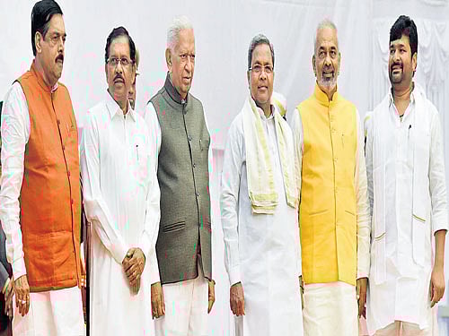 (From left) Manohar Tashildar, G Parameshwara, Governor Vajubhai Vala, Chief Minister Siddaramaiah, A Manju and Vinay Kulkarni after the swearing-in ceremony at Raj Bhavan in Bengaluru on Thursday. DH Photo/ M S MANJUNATH
