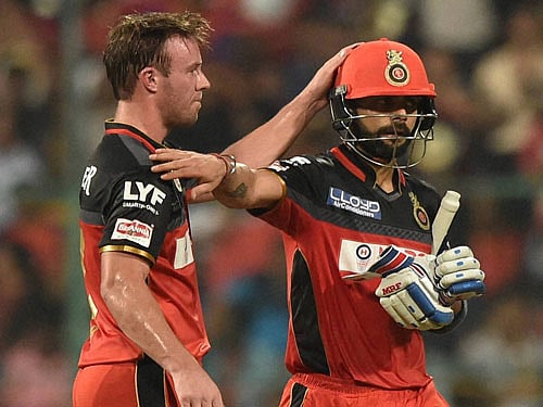 Royal Challengers Bangalore Virat Kohli returns the pavilion after his dismissal as AB De Villiers congratulate him during the IPL 2016 match against Sunrisers Hyderabad at Chinnaswamy stadium in Bengaluru on Tuesday. PTI Photo